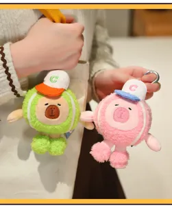 Nahaufnahme von niedlichen Capybara-Plüschanhängern mit Tennis-Thema in Rosa und Grün