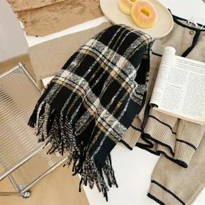 Gros plan d'une écharpe d'hiver à carreaux vintage avec franges sur une table