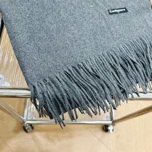 Vista detallada de bufanda de cachemira gris oscuro con flecos elegantes y textura suave