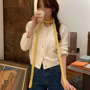 Vue détaillée d'une écharpe en maille jaune style chenille portée par un mannequin