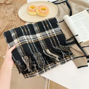 Gros plan d'une écharpe à carreaux rétro montrant la texture en maille douce et les franges