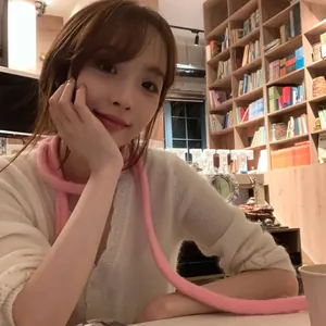 Écharpe en maille chenille rose chic portée par un mannequin dans une bibliothèque.