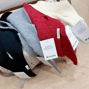 Detailed macro view of multi-colored wool knit triangular headscarves with brand tags