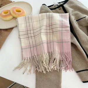 Weicher rosa karierter Schal mit Fransen, kombiniert mit einer warmen Strickjacke.