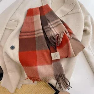 Detailed view of 100% wool plaid scarf featuring elegant tassels and material label
