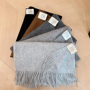 Close-up detail of various 100% Australian wool scarves with soft fringe texture.