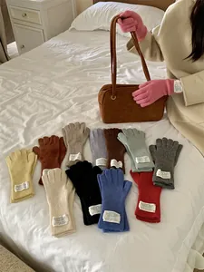 Cozy multi-colored knitted cashmere-like gloves for women shown in lifestyle setting.