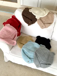 Assorted colors of knitted beanies with bear ears for winter warmth and cute style.