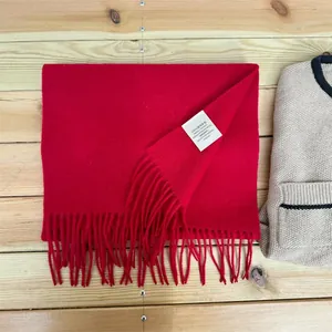 Detail view of premium 100% Australian wool red scarf with fringe and material label