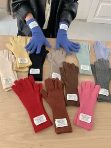 Detailed display of assorted colorful winter knitted gloves with unique fabric brand labels