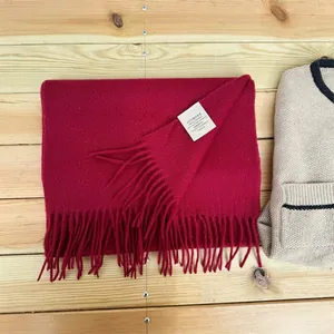 Detail of a 100% Australian wool scarf in deep burgundy with elegant fringe tassels