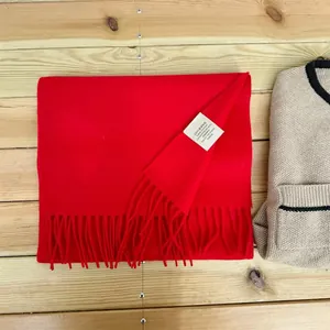 Close-up view of a red 100% Australian wool scarf showing the authentic material care label