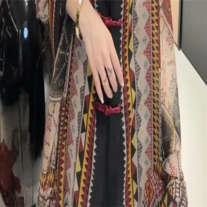 Detailansicht eines Schals mit Ethno-Muster und roten Verschlüssen.