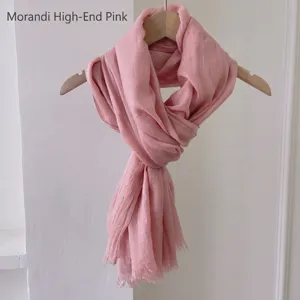 Dettaglio scialle rosa Morandi effetto lino su gruccia in legno per viaggi