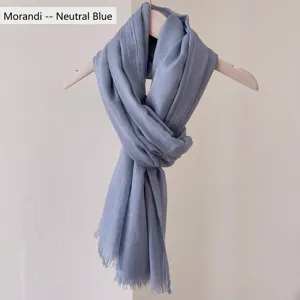 Vista dettagliata della sciarpa in cotone-lino blu Morandi con eleganti bordi sfrangiati