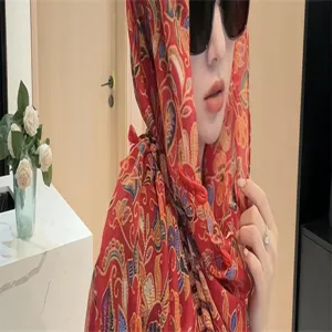 Detailansicht eines roten Schals mit Paisley-Muster und traditionellen Knebelknöpfen.
