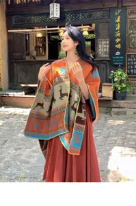 Bohemian orange shawl with reindeer and snowflake ethnic patterns worn by model