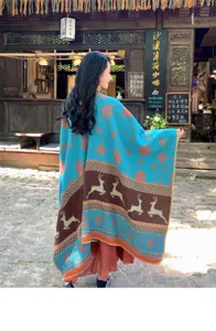 Large teal knit shawl cloak with reindeer and snowflake patterns for winter warmth