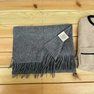 Close-up detail of a soft grey 100% Australian wool scarf featuring elegant fringe tassels