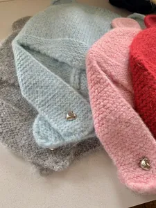 Detail view of colorful fuzzy knitted beanies with cute bear ears and heart charms