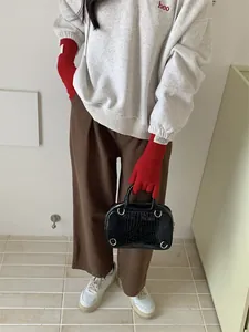 Detailed view of long red knit gloves featuring finger holes for easy touchscreen use