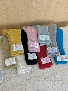 Multi-color knitted wool gloves with fabric Grove labels for winter warmth and style.