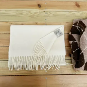 Detail of cream white 100% Australian wool scarf with soft tassels and care label
