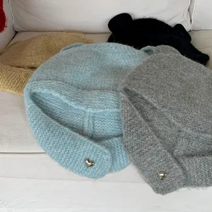 Group of cute bear ear knitted beanies in multiple colors with heart accents.