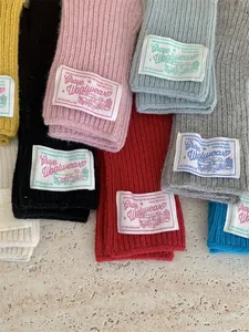 Macro view of colorful knitted wool gloves featuring vintage Grove Woolwear patches