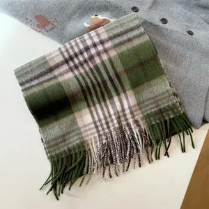 Close-up detail of green plaid 100% wool scarf with soft fringed tassels