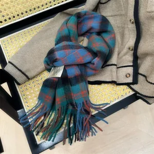 Close-up of 100% wool plaid scarf with tassels on a cozy knitted cardigan background.