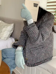 Cozy light green knitted gloves with woven label worn in a winter lifestyle setting