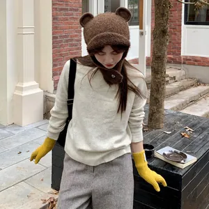 Asian model wearing a cozy brown bear-ear knit hat in a stylish outdoor setting