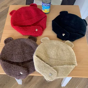Detailed top view of four plush bear ear knitted hats in assorted winter colors on a table