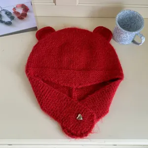 Close-up detail of red bear ear knitted winter beanie featuring cozy fur texture