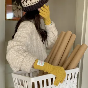 Cozy mustard yellow knit wool gloves with a stylish cloth label for warm winter wear.