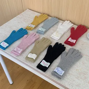 Assorted colorful knitted wool gloves with woven labels, perfect for warm winter daily wear.