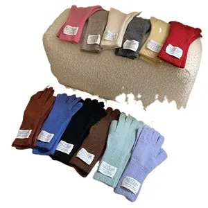 Assorted colorful warm knit gloves displayed on a textured sherpa-style footstool