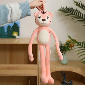 Detailed view of a long-legged pink tiger plush toy being held up in a cozy home setting