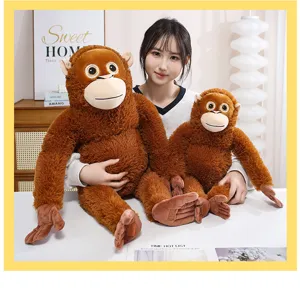 Asiatisches Model hält zwei niedliche braune Orang-Utan-Plüschtiere in warmem Zuhause