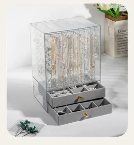 Detalle de joyero de acrílico transparente con cajones de terciopelo gris.
