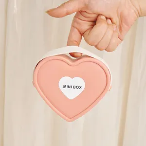 Portable pink heart-shaped jewelry storage box for travel and lipstick organization.