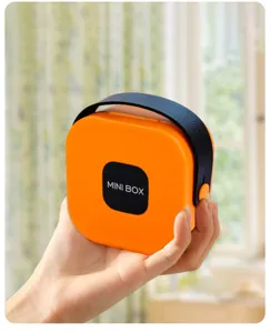 Close-up of a portable orange mini storage box with a black handle strap held by hand