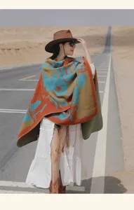 Stylish bohemian patterned knit poncho shawl wrap with tassels worn on a scenic desert road