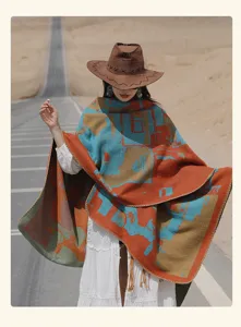 Model wearing a colorful abstract knit shawl poncho in a desert road setting