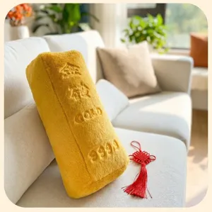 Détail d'un coussin créatif en peluche en forme de lingot d'or sur un canapé blanc