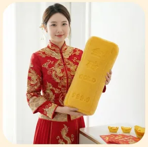 Gros plan d'un coussin en peluche créatif en forme de lingot d'or tenu par un modèle