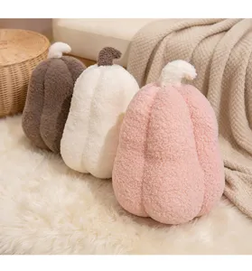 Cozy sherpa pumpkin pillows in pink, white, and brown on a soft white shaggy rug