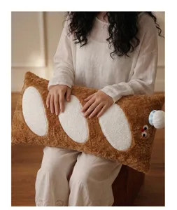 Vue détaillée d'un adorable coussin en peluche baguette tenu dans une pièce intérieure douillette.