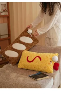 Vue détaillée de jolis coussins en peluche baguette et crevette dans un cadre douillet.